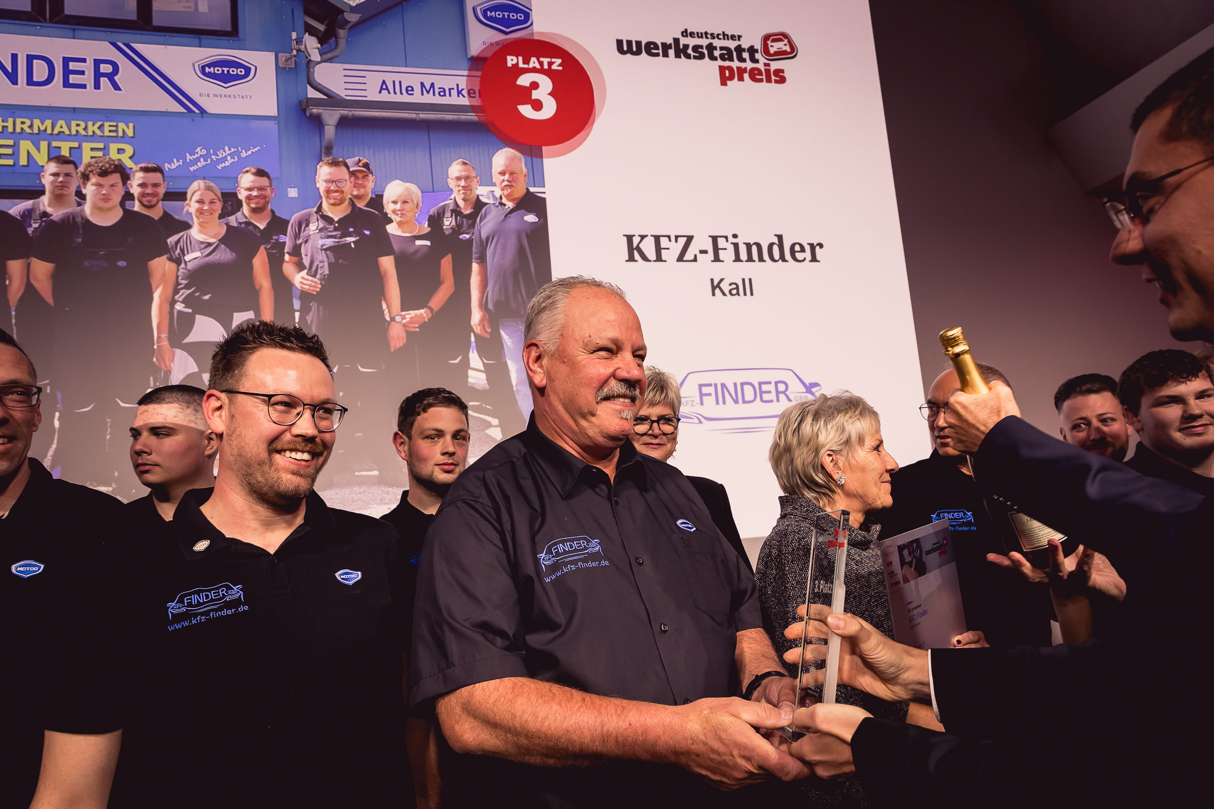 Inhaber Wilfried und Sebastian Finder von KFZ-Finder GbR halten stolz die Auszeichnung für den 3. Platz beim Deutschen Werkstattpreis 2024 in Würzburg. Kurz nach der Preisverleihung präsentieren sie den Erfolg, der für herausragenden Service und Innovation in der Werkstattbranche steht. Bildquelle: Stefan Bausewein.